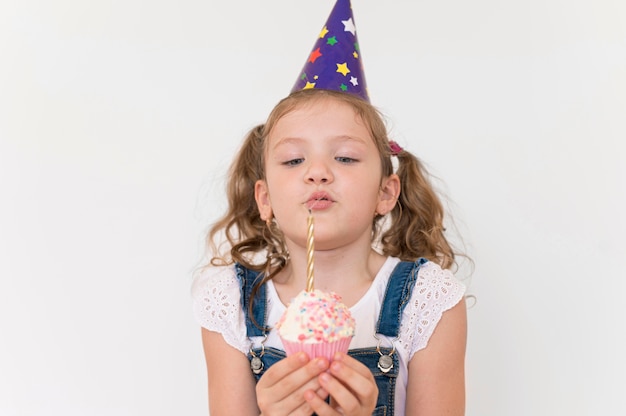 Medium shot girl blowing candle