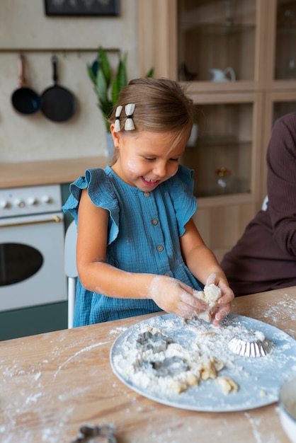 Foto gratuita ragazza del colpo medio che cucina in cucina