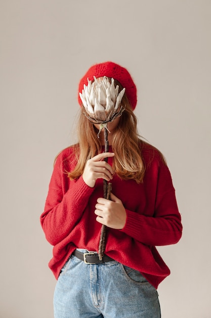 Medium shot girl covering her face with flower