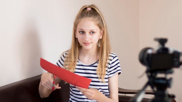 medium shot girl cutting paper