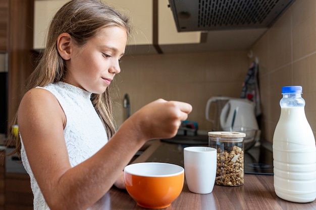 Medium shot of girl eating cereals