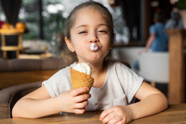 중간 샷 여자 아이 식사 아이스크림