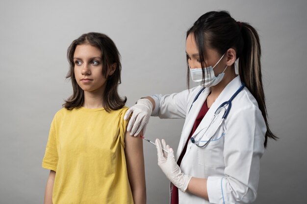 Medium shot girl getting vaccinated