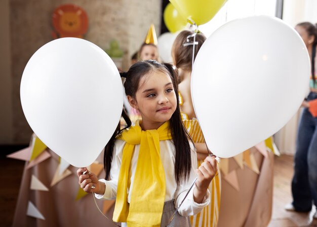 Medium shot girl holding balloons