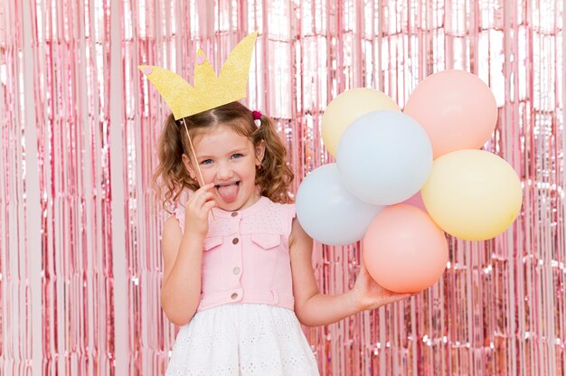 Medium shot girl holding colorful balloons