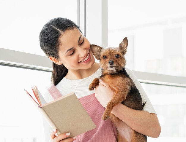 Free photo medium shot girl holding dog and book