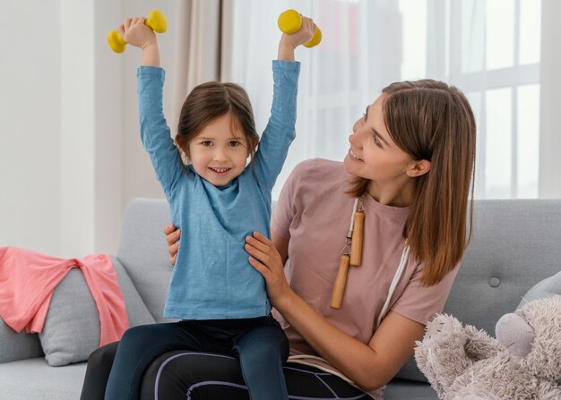 Medium shot girl holding dumbbells