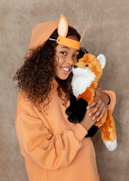 Medium shot girl holding fox toy