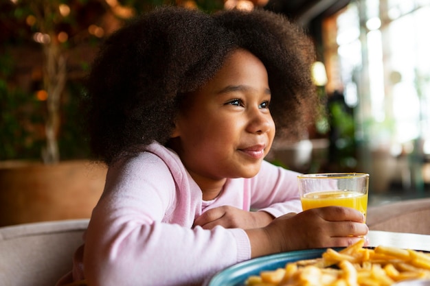 Free photo medium shot girl holding glass with juice