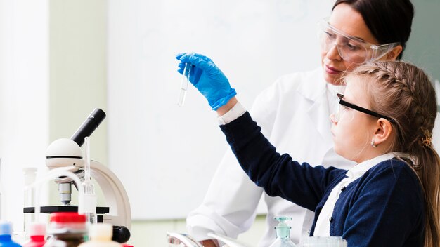 Medium shot girl holding lab tube