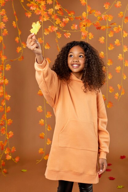 Medium shot girl holding leaf