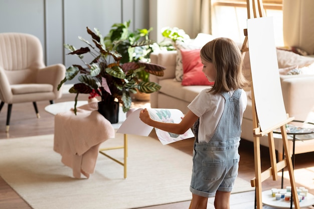 Medium shot girl holding painting