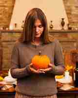 Free photo medium shot girl holding pumpkin