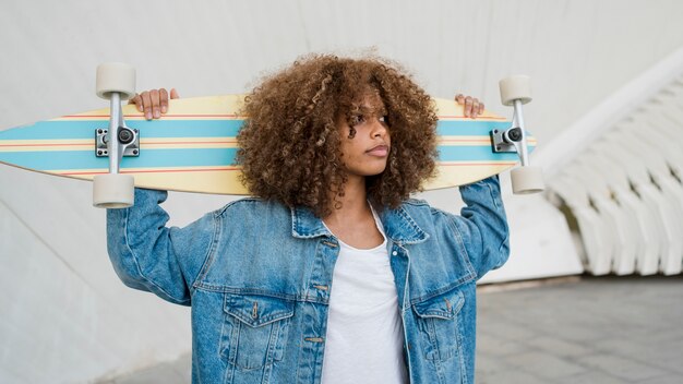 Medium shot girl holding skateboard