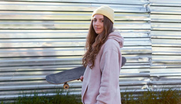 Medium shot girl holding skateboard