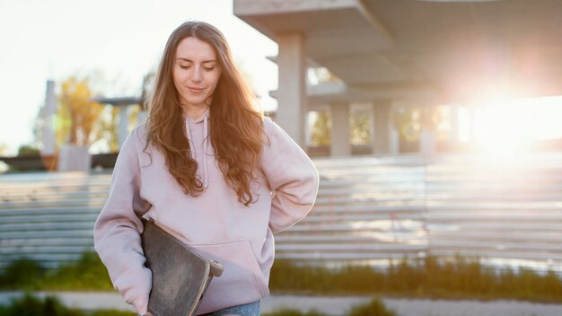 スケートボードを持っているミディアムショットの女の子