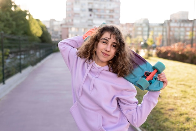 Medium shot girl holding skateboard