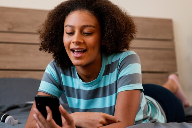 Free photo medium shot girl holding smartphone