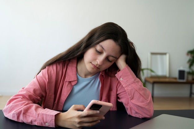 Medium shot girl holding smartphone