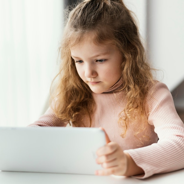 Free photo medium shot girl holding tablet