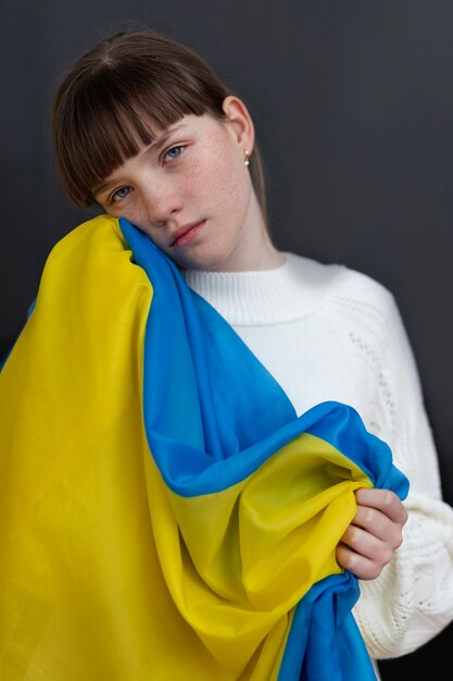 Medium shot girl holding ukranian flag