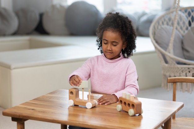 Free photo medium shot girl kid playing with eco toys