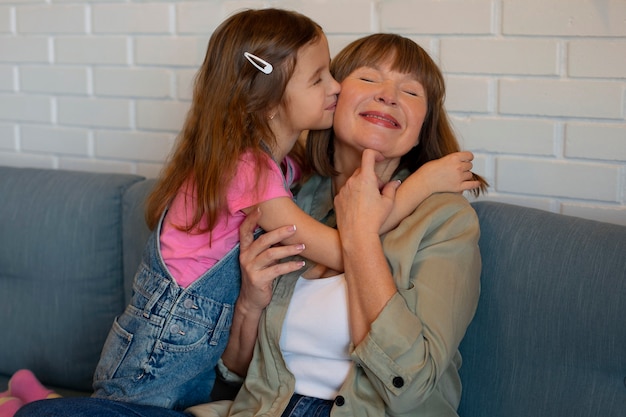 Medium shot girl kissing granny