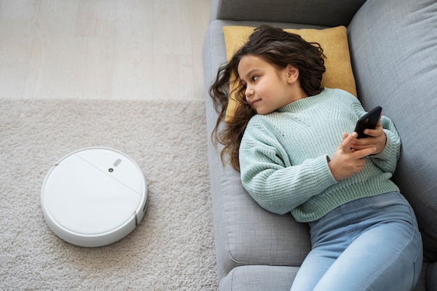 Free photo medium shot girl laying on couch with smartphone