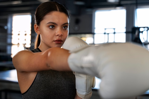 Medium shot girl learning boxing