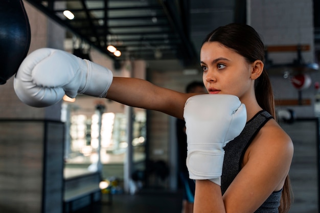 Medium shot girl learning boxing