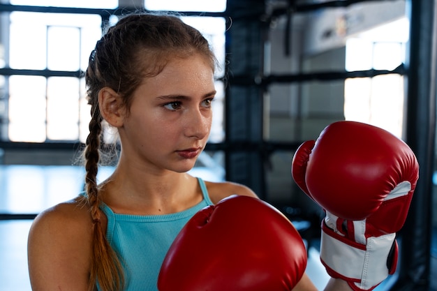 Medium shot girl learning boxing