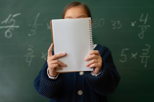 Foto gratuita ragazza di tiro medio che impara la matematica a scuola