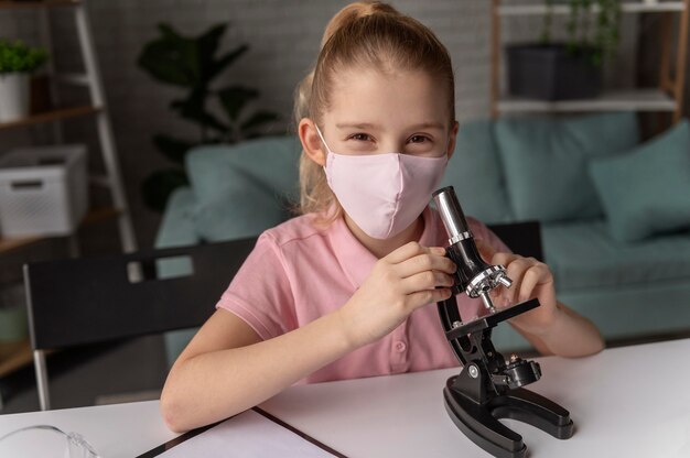 Medium shot girl learning with microscope