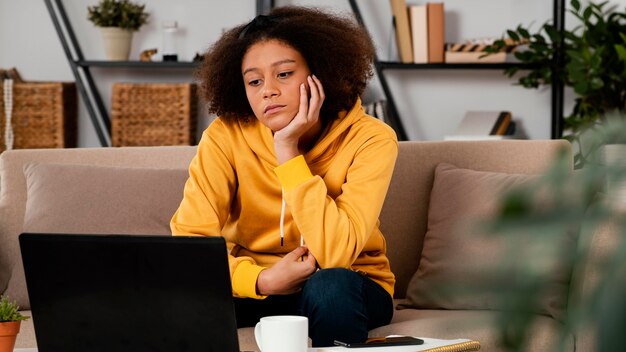 Medium shot girl looking at laptop