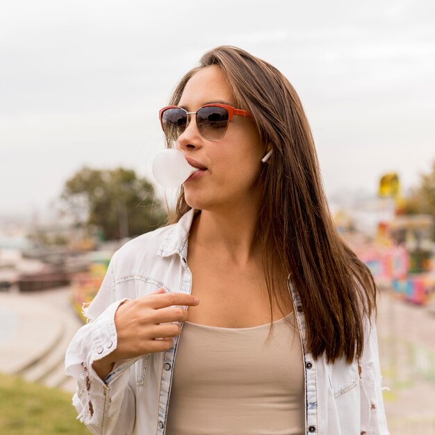 Medium shot girl making gum balloon