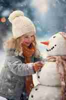 Free photo medium shot girl making snowman