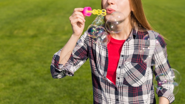 Free photo medium shot girl making soap bubbles