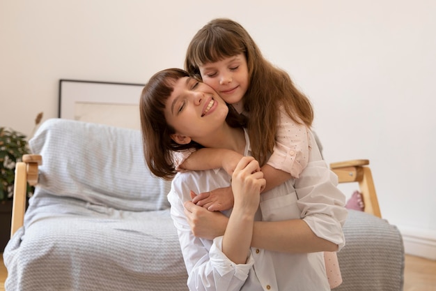 Free photo medium shot girl and mother hugging