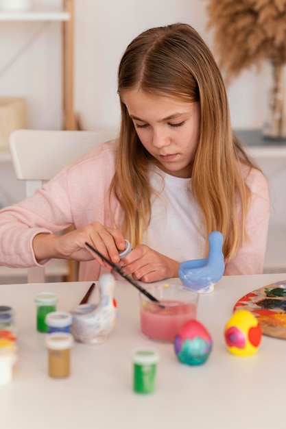 ミディアムショットの女の子がペンキの容器を開ける