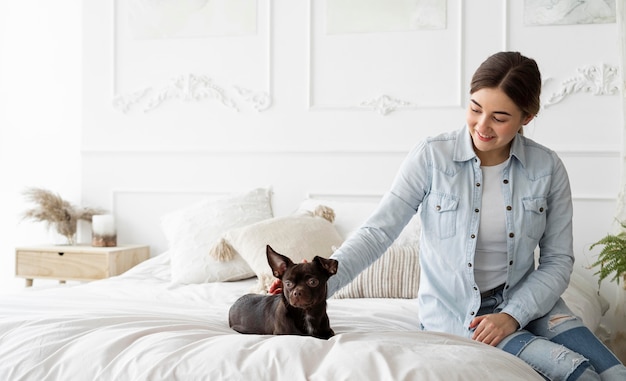 Medium shot girl petting dog in bed