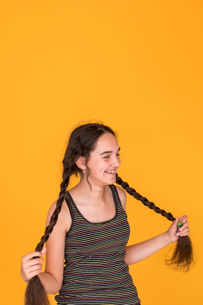 Medium shot girl playing with her braids