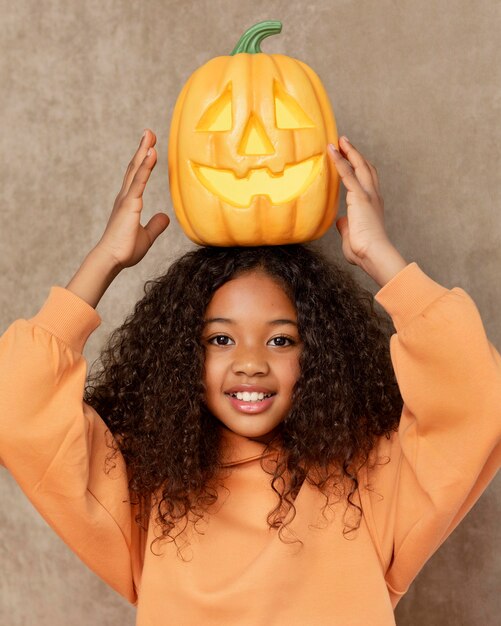 Medium shot girl posing with pumpkin