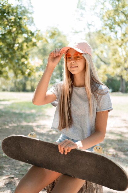 Medium shot girl posing with skateboard