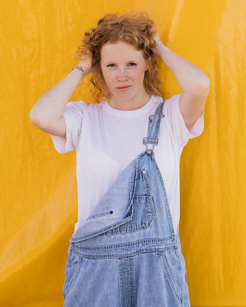 Medium shot girl posing with yellow background