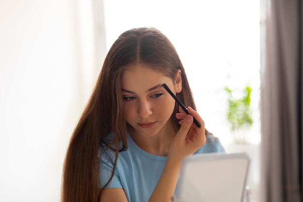 Free photo medium shot girl putting on makeup