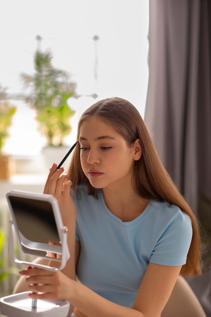 Medium shot girl putting on makeup