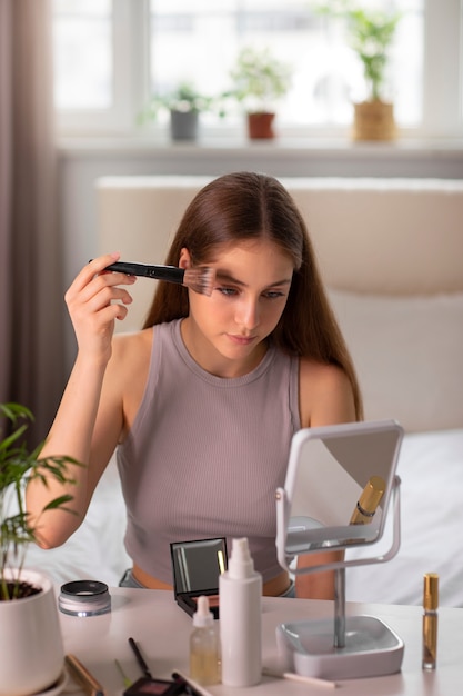 Free photo medium shot girl putting on makeup