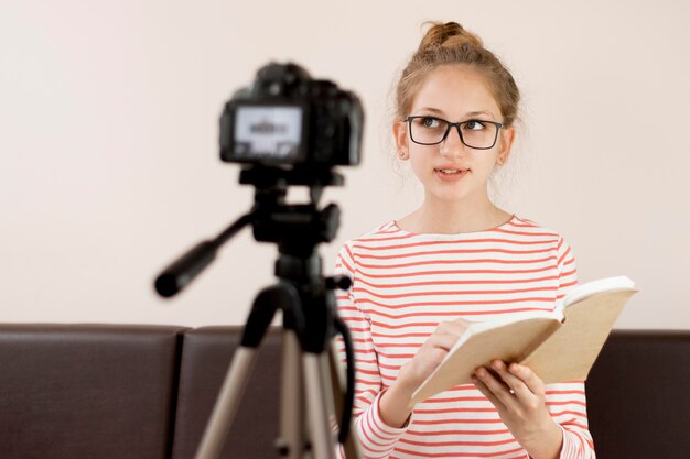 Medium shot girl reading on camera