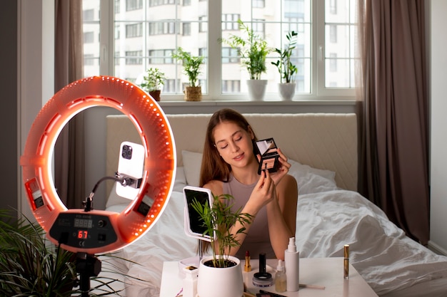 Medium shot girl recording her makeup routine