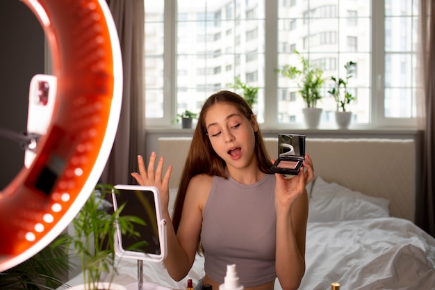 Medium shot girl recording her makeup routine